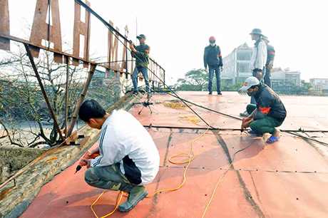 Các lực lượng chức năng tiến hành tháo dỡ mái tôn nhà chợ chính (Khu A)