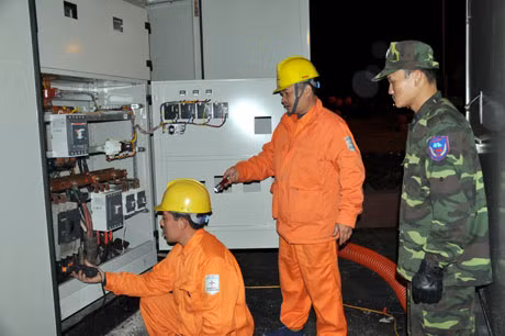 Các nhân viên công ty điện lực kiểm tra trạm biến áp đảm bảo điện lưới phục vụ nhân dân