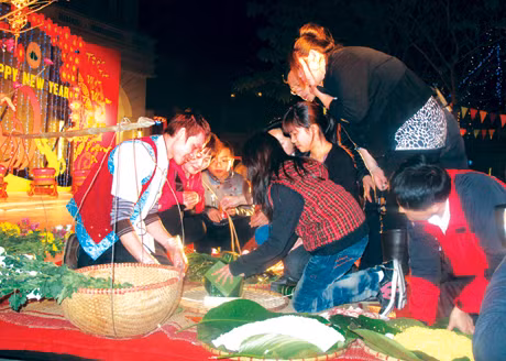 Nhân viên ngành du lịch hướng dẫn du khách gói bánh chưng trong đêm giao thừa Tân Mão 2011.