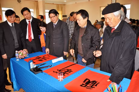 ảnh 5: Nhà nghiên cứu văn hóa dân gian Tồng Khắc Hài, nhà báo Ngô Mai Phong và họa sĩ Nguyễn Văn Toàn khởi thảo 3 chữ Chúc Tân Xuân.