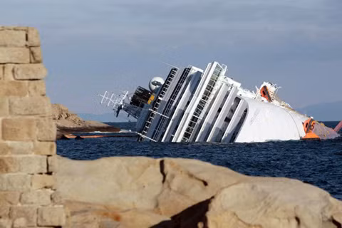 Du thuyền Costa Concordia nằm lật nghiêng bên bờ biển đảo Giglio, Italy. Ảnh: AP