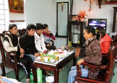 Em Đặng Văn Tới (ngoài cùng, bên trái) vui Tết cùng bạn bè, gia đình trong căn nhà mới.