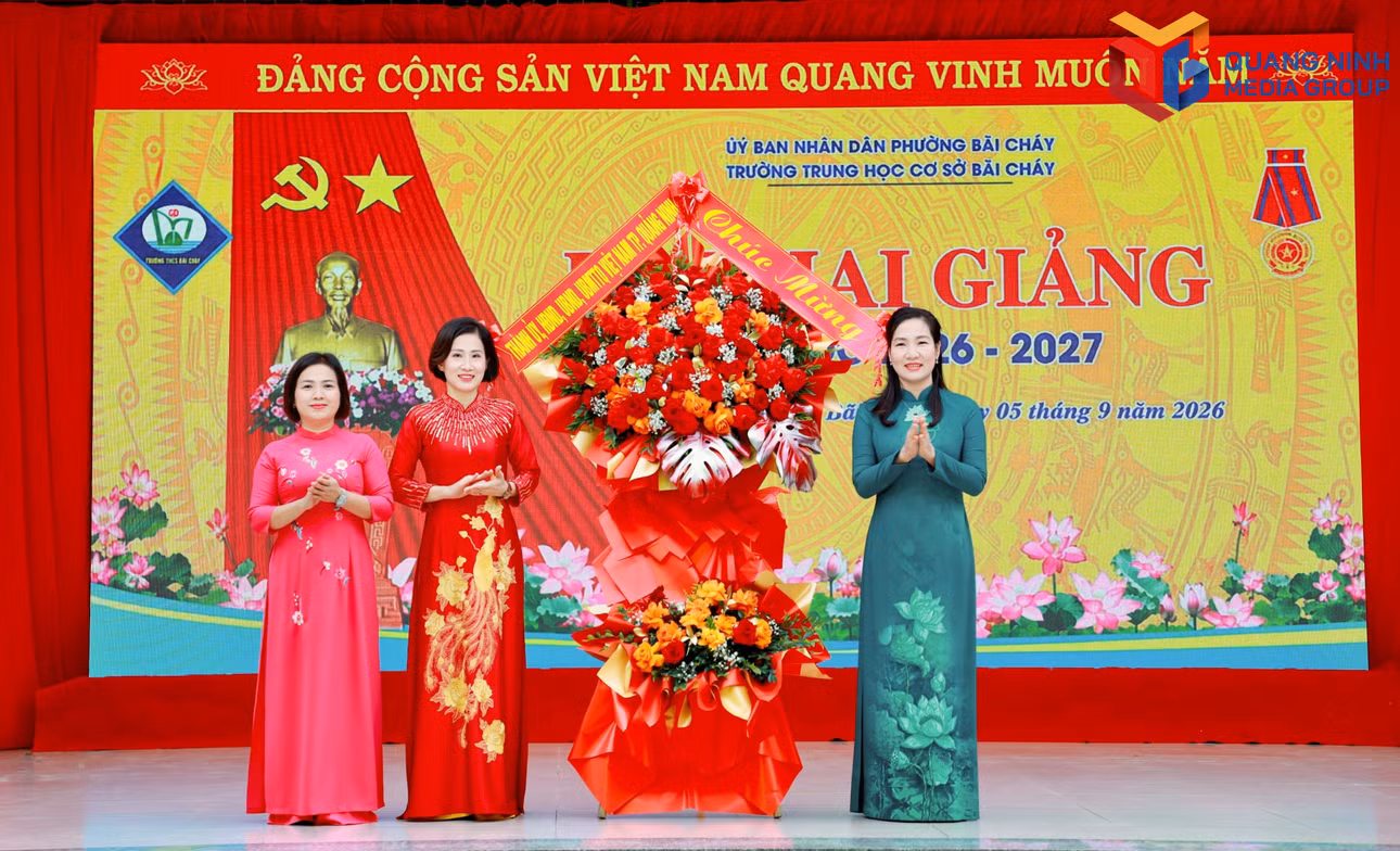 Đồng chí Nguyễn Thị Hạnh, Ủy viên Ban Thường vụ, Trưởng Ban Tuyên giáo Thành ủy, tặng hoa chúc mừng tập thể thầy cô giáo và học sinh Trường THCS Bãi Cháy.