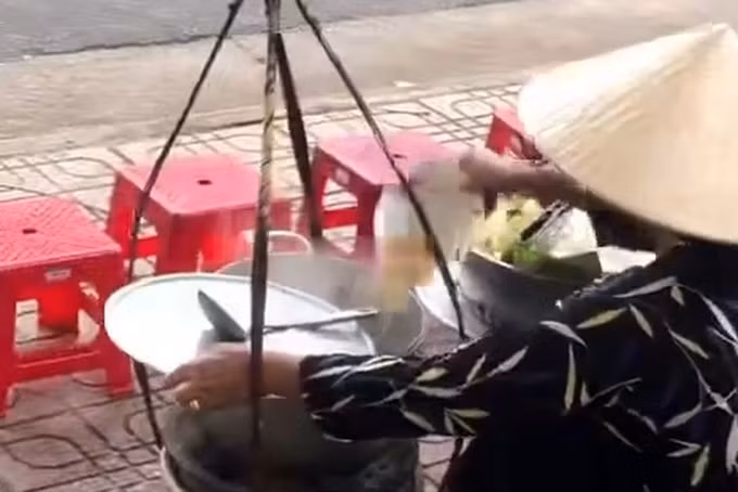 Hành vi được cho là đổ thức ăn thừa vào nồi (Ảnh: Chụp từ clip).