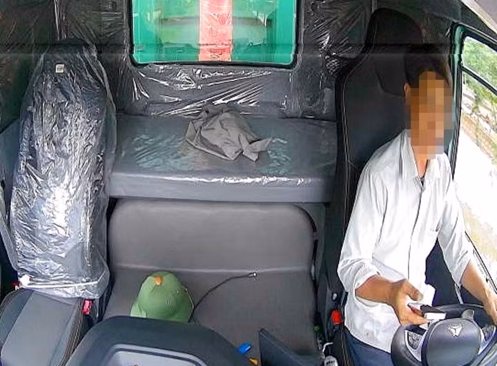 Tài xế không đeo dây an toàn, sử dụng điện thoại khi đang lái xe tải. (Ảnh: Công an Thanh Hoá)