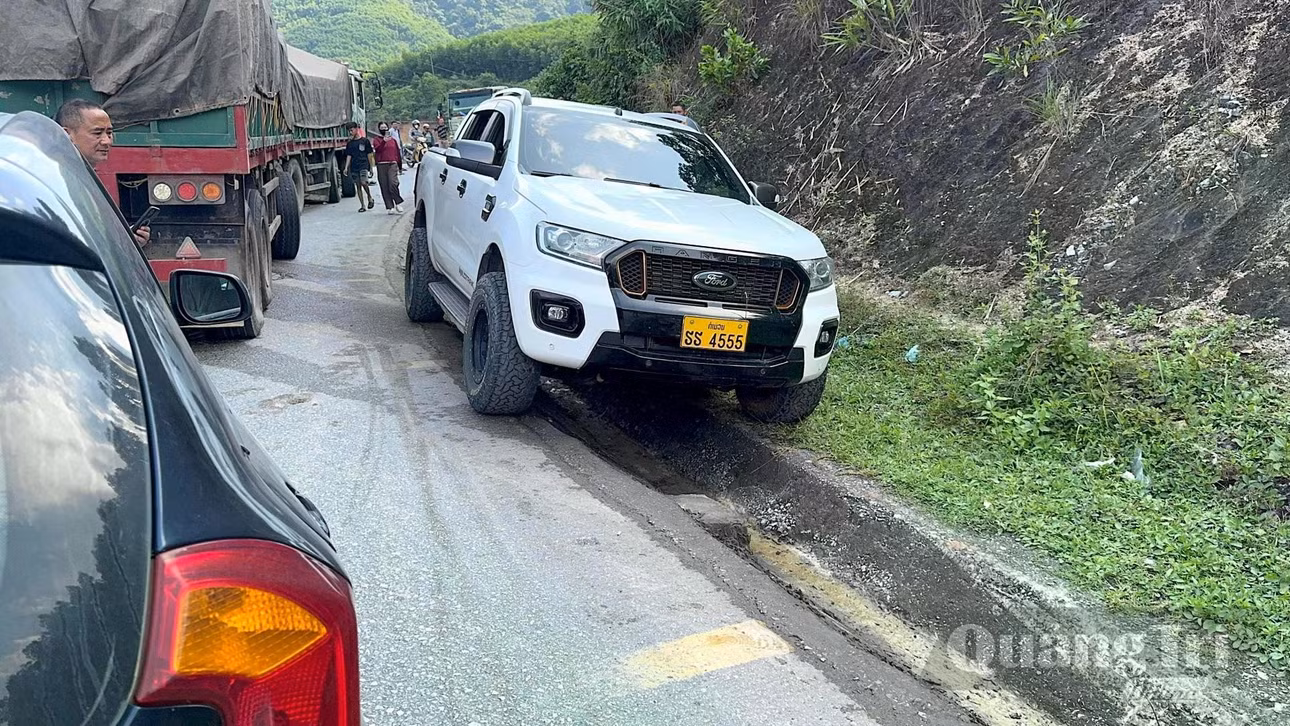 Một số phương tiện tìm cách vượt qua vị trí ùn tắc theo rãnh thoát nước ven đường - Ảnh: Quang Ngọc