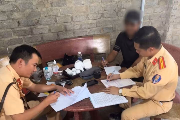 Cán bộ Phòng CSGT Công an tỉnh Thanh Hoá làm việc và lập biên bản vi phạm hành chính với tài xế Đ.V.Q. (Ảnh: Công an tỉnh Thanh Hoá)