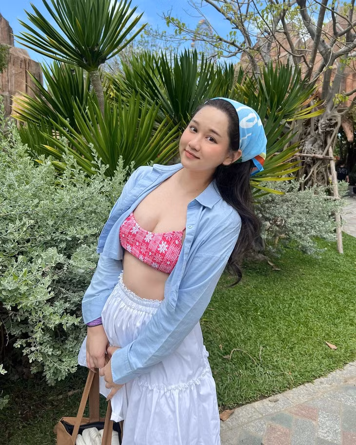 Trúc Anh khoe dáng đầy đặn, khoẻ khoắn, mang đậm không khí mùa hè trong chuyến du lịch. Mỹ nhân phim ‘Mắt biếc’ khoác sơ mi bên ngoài chiếc áo tắm màu hồng nổi bật, phối cùng váy trắng, bandana buộc tóc.