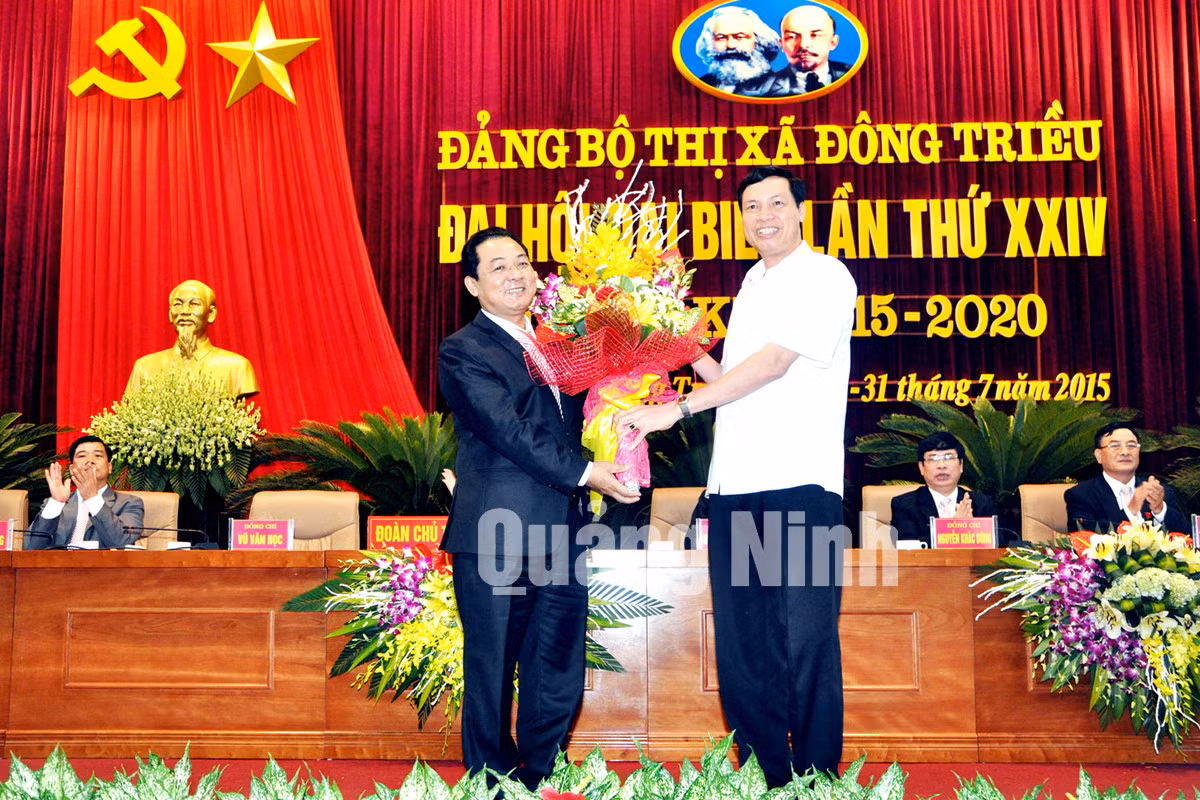 Đồng chí Nguyễn Đức Long, Phó Bí thư Tỉnh ủy, Chủ tịch UBND tỉnh tặng hoa chúc mừng đồng chí Vũ Văn Học, Bí thư Thị ủy Đông Triều nhiệm kỳ 2010-2020