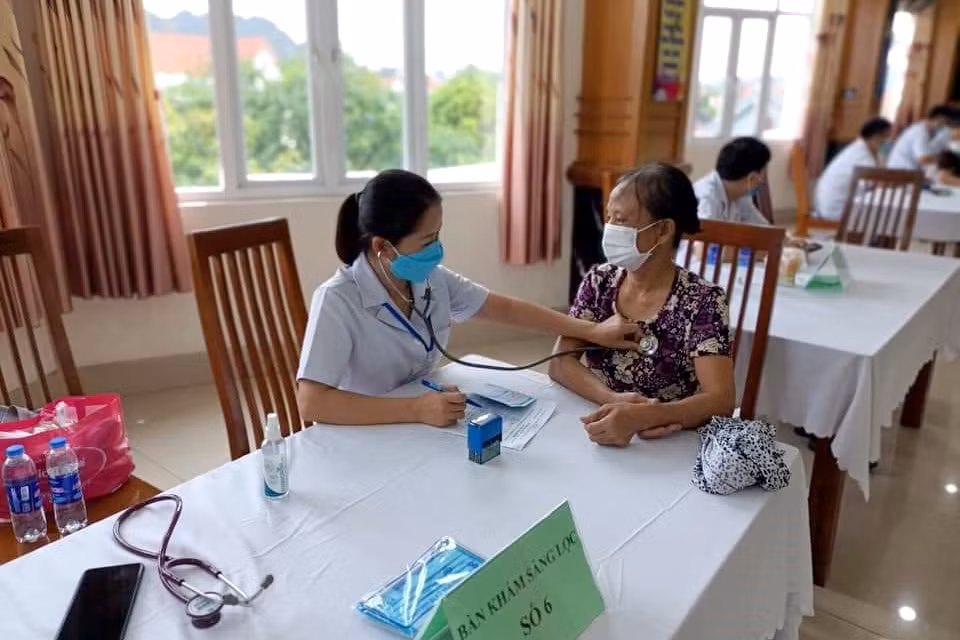 Cán bộ y tế khám sàng lọc cho người dân TP Cẩm Phả trước khi tiêm vắc-xin.