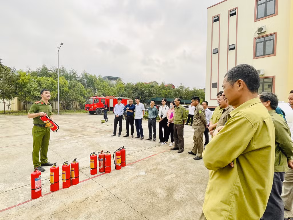 Cán bộ Đội Cảnh sát PCCC&CNCH (Công an TP Uông Bí) hướng dẫn sử dụng bình chữa cháy.