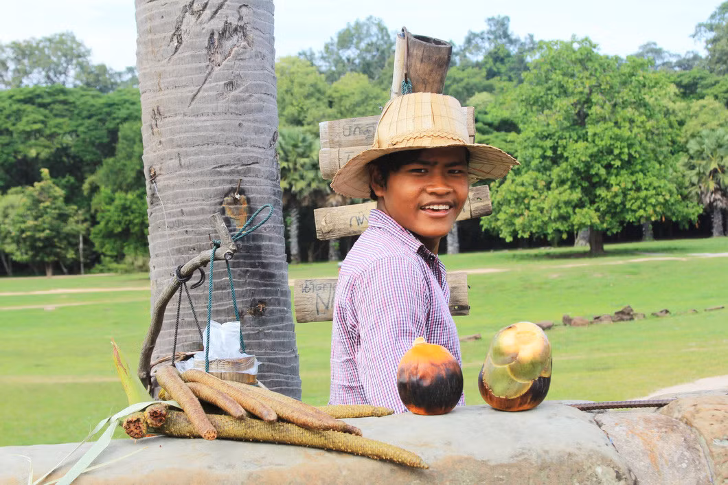 Một người Campuchia đang bán nước thốt nốt tươi trong quần thể Angkor - Ảnh: MINH HUYỀN