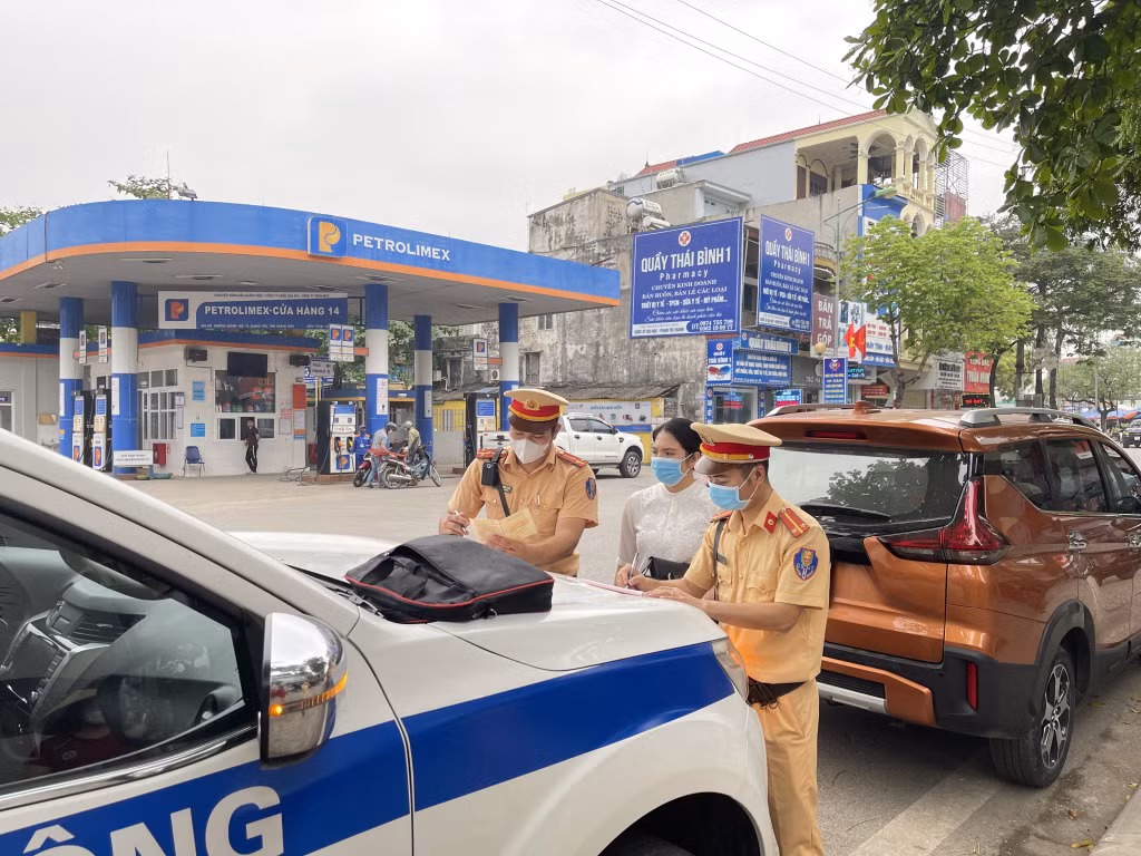 Lực lượng CSGT Công an TX Quảng Yên lập biên bản vi phạm đối với chủ phương tiện dừng, đỗ sai quy định.