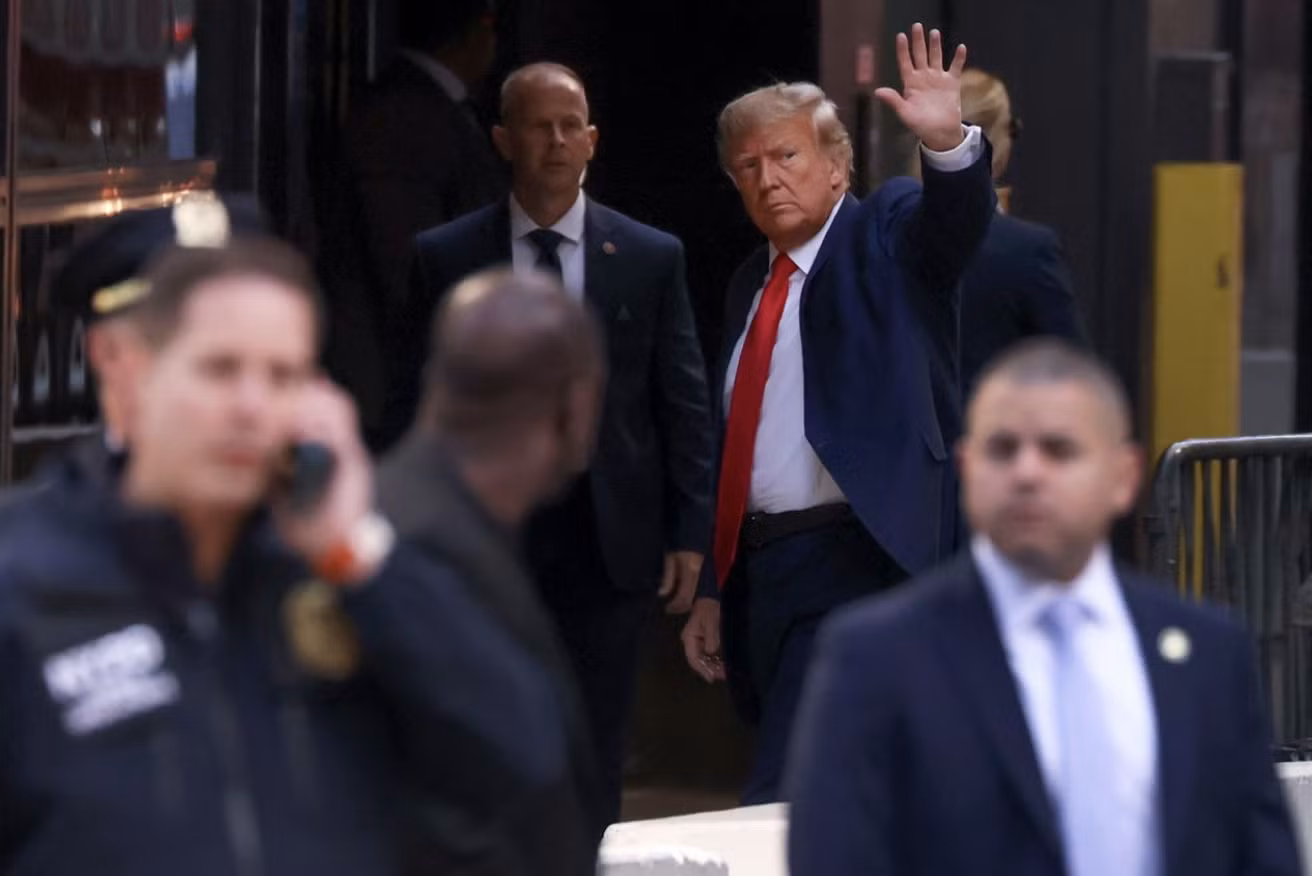 Ông Trump vẫy tay chào những người ủng hộ trước khi bước vào Tháp Trump. Ảnh: AP