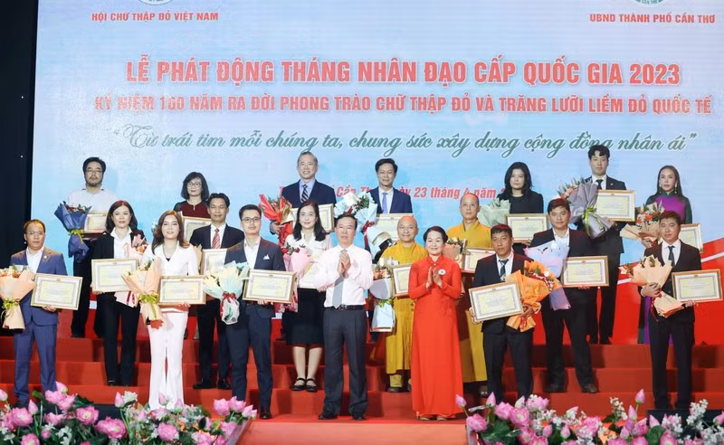 Chủ tịch nước Võ Văn Thưởng, Chủ tịch danh dự Hội Chữ thập Đỏ Việt Nam và bà Bùi Thị Hòa, Chủ tịch Hội Chữ thập Đỏ Việt Nam tặng hoa và trao bảng Ghi nhận tấm lòng vàng nhân đạo. (Ảnh: TTXVN)