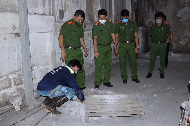 Cơ quan chức năng kiểm tra hầm chứa trong xí nghiệp của Công ty Điện Quang - Ảnh: T.T