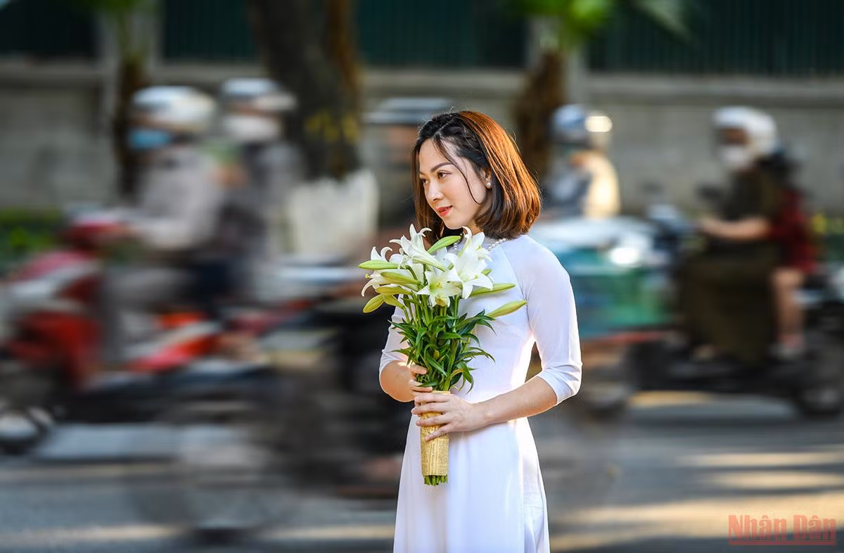 Những người yêu hoa ưu ái chọn cho mình chiếc áo dài trắng để lưu lại khoảnh khắc nên thơ của Thủ đô trong mùa loa kèn. (Ảnh: THÀNH ĐẠT)