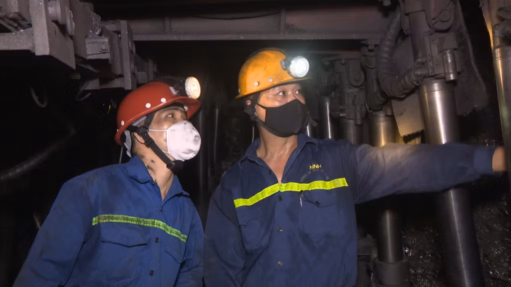 Anh Nguyễn Văn Linh, công nhân Phân xưởng Khai thác đào lò 16 (bên trái) trao đổi công việc với đồng nghiệp.