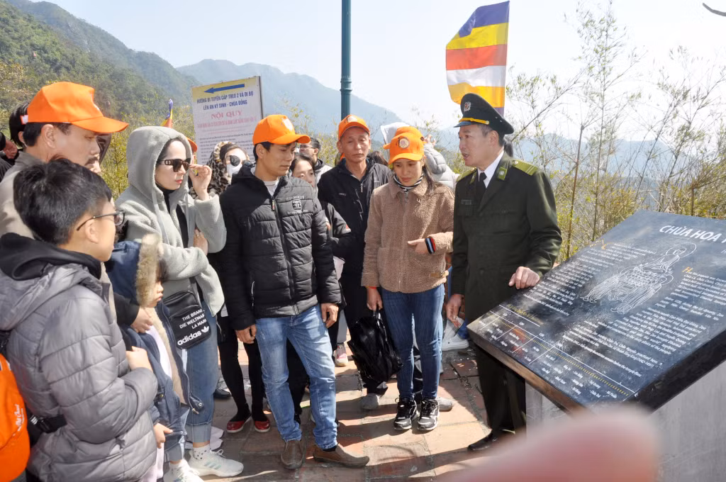 Cán bộ Ban quản lý Di tích và Rừng quốc gia Yên Tử giới thiệu cho du khách về chùa Hoa Yên tại Yên Tử.