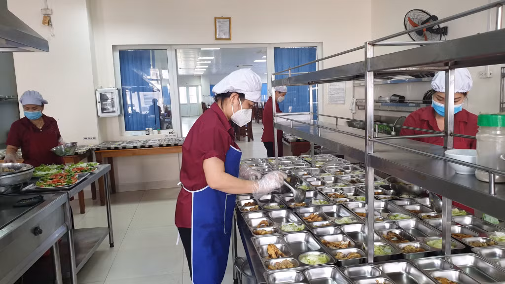 Nhân viên Công ty CP Tâm Đức Cẩm Phả phục vụ suất ăn ca cho người lao động của Công ty Tuyển than Cửa Ông - TKV.