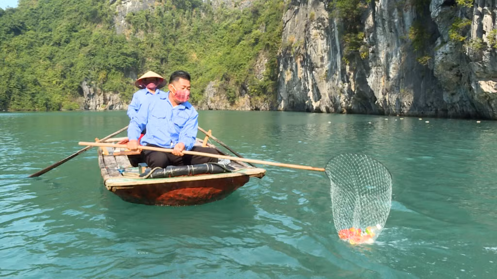 Nhân viên Công ty CP Cây xanh công viên Quảng Ninh thu gom, vớt rác trên vịnh Hạ Long. Ảnh: Lê Nam