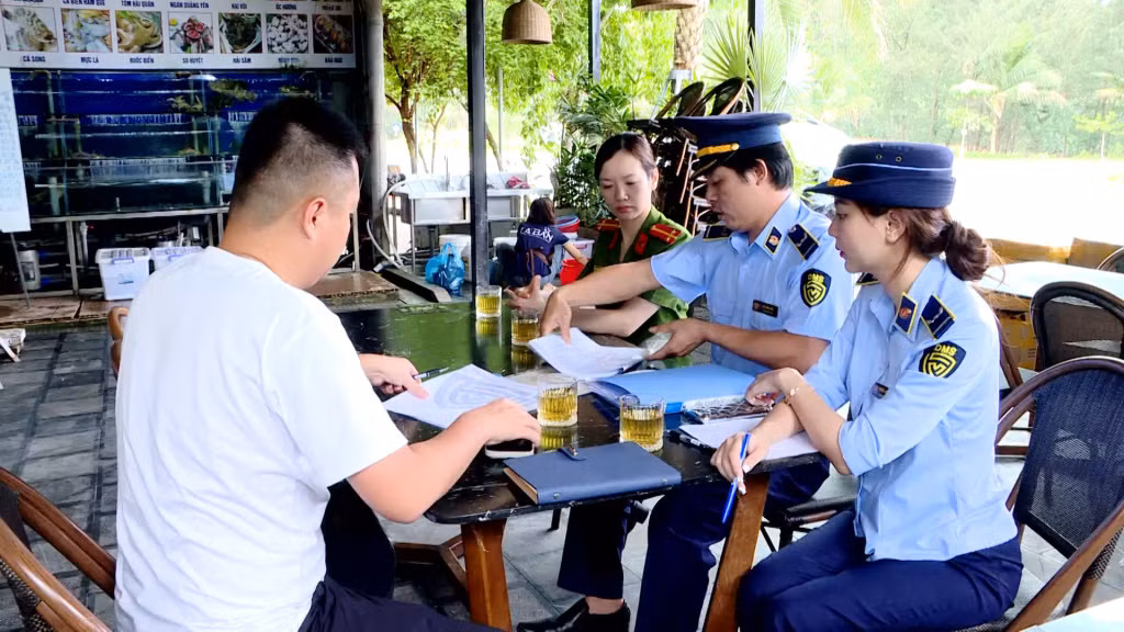 Lực lượng chức năng hướng dẫn một cơ sở dịch vụ tại Vân Đồn về vấn đề niêm yết giá.