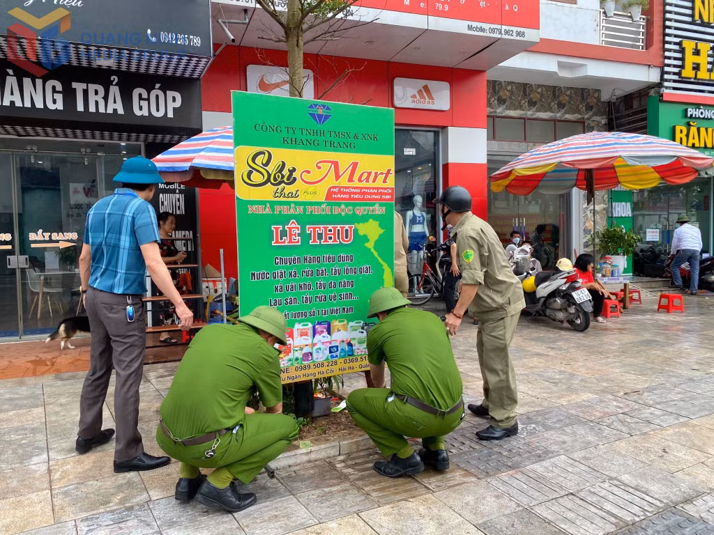 Lực lượng chức năng xã Quảng Hà tháo dỡ, xử lý các biển báo lấn chiếm vỉa hè, lòng đường.