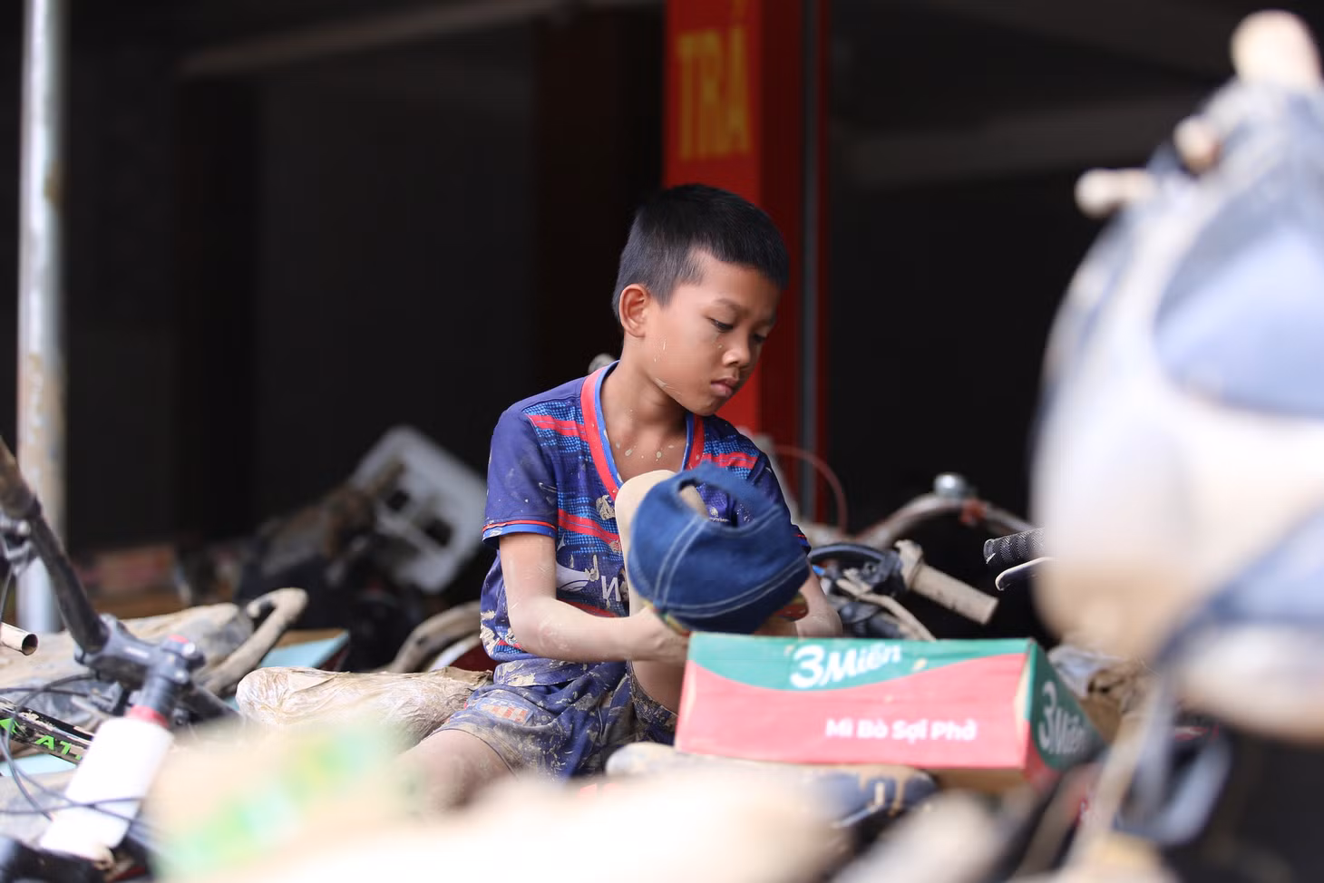 Một em bé cùng thùng mì vừa được phát cứu trợ.