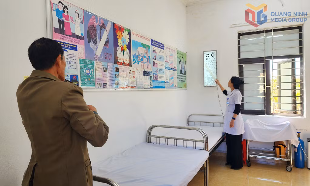 Nhân viên Trạm Y tế phường Đông Mai hướng dẫn người dân kiểm tra thị lực trong buổi khám sức khỏe.