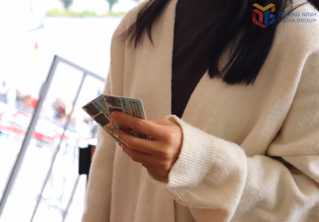Người dân chuẩn bị sẵn CCCD chờ đến lượt đổi vé.