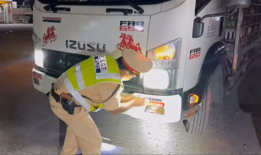 CSGT Công an tỉnh Tây Ninh dán decal phản quang với khẩu hiệu “Về nhà an toàn” cho xe tải, container. Ảnh: Công an cung cấp