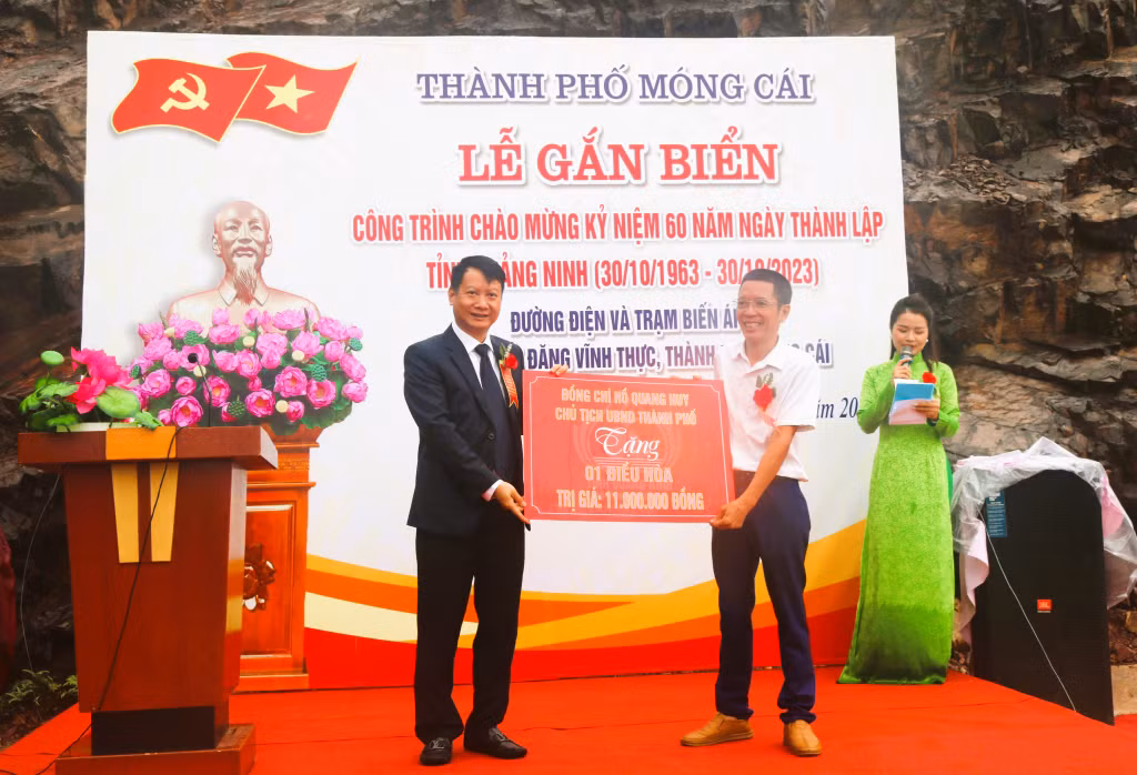 Ông Đồng Văn Cường, Trạm trưởng (áo trắng) hân hoan nhận món quà ý nghĩa từ Chủ tịch UBND TP Móng Cái Hồ Quang Huy.