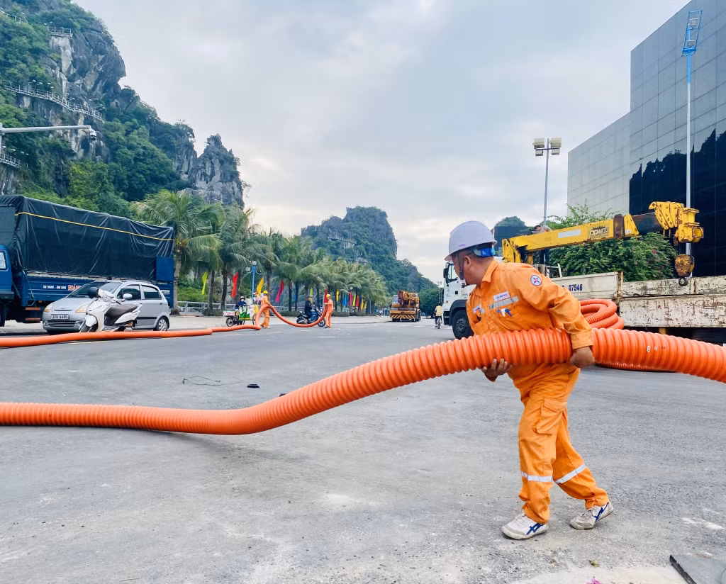 Công nhân Điện lực TP Hạ Long kéo dây, lắp đặt thiết bị để kéo nguồn cấp điện lưới cho khu vực Quảng trường.