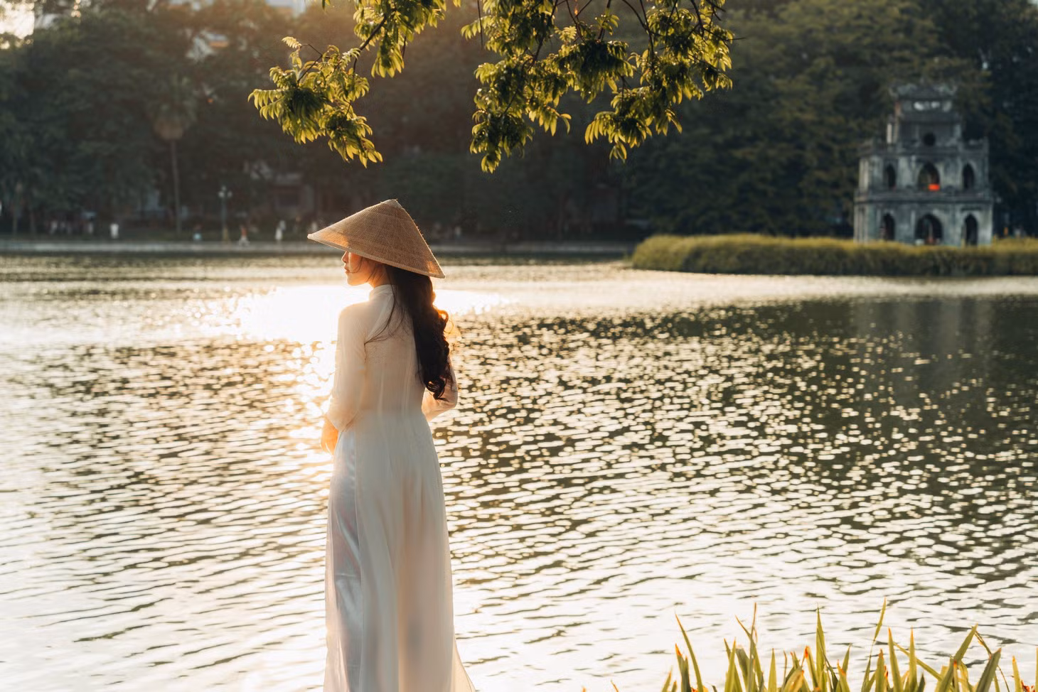 Ánh nắng chiều đổ xuống hồ Hoàn Kiếm, xa xa là Tháp Rùa cổ kính.