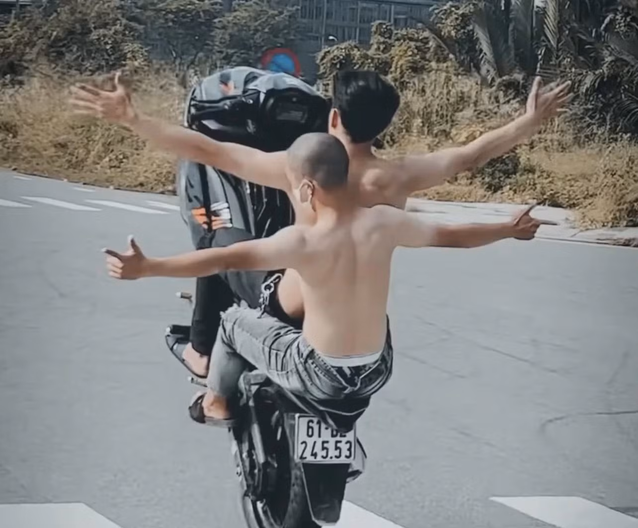 Hai thanh niên ngồi trên xe thả tay.