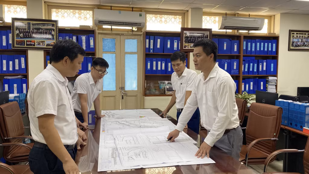 Kỹ sư Đặng Văn Phong (ngoài cùng, bên phải) trao đổi về sáng kiến mới trong công việc.