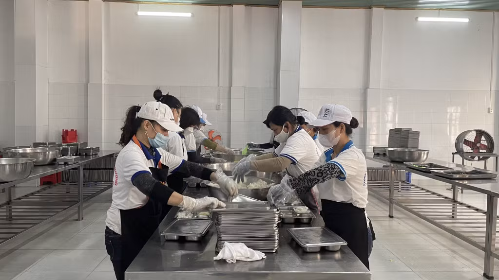 Nhân viên Công ty TNHH Thương mại sản xuất cơm hộp Hải Hương chia cơm cho học sinh ăn bán trú ở các trường học tại TP Cẩm Phả.
