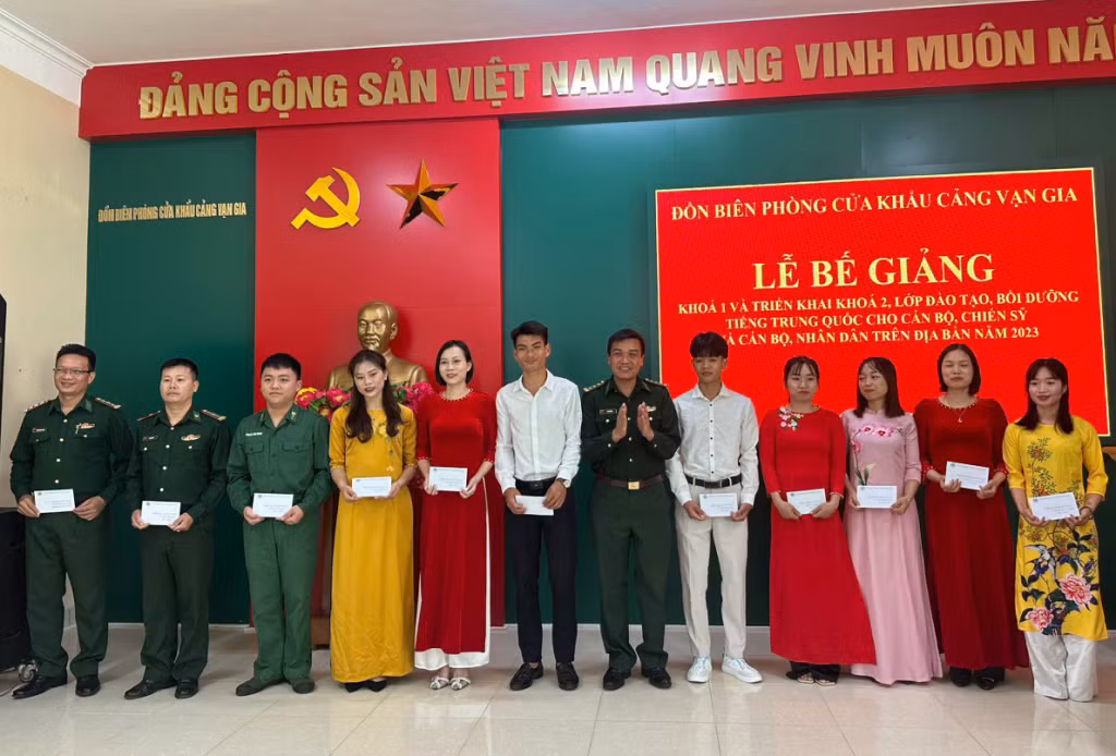 Lãnh đạo Đồn biên phòng Cửa khẩu cảng Vạn Gia tặng hoa chúc mừng lớp học. (Ảnh do đơn vị cung cấp)