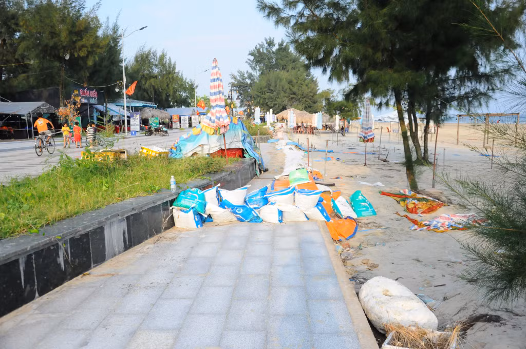 Các hộ kinh doanh tại Khu du lịch Trà Cổ sử dụng các bao cát để chắn nước mưa chảy tràn trên đường dạo xuống khu vực kinh doanh gây mất mĩ quan khu du lịch