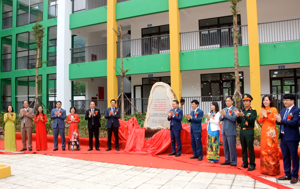 Các đại biểu thực hiện nghi thức gắn biển công trình Trường Tiểu học và THCS xã Vạn Yên.