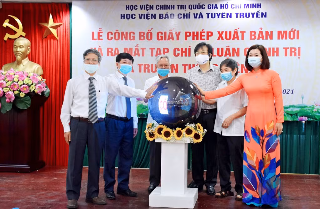 Các đại biểu thực hiện nghi thức ấn nút khai trương Tạp chí Lý luận chính trị và Truyền thông điện tử