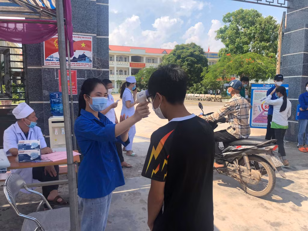 ĐVTN tiếp sức mùa thi hỗ trợ đo thân nhiệt cho thí sinh trước khi vào phòng thi tại điểm thi Trường THPT Đầm Hà (huyện Đầm Hà).