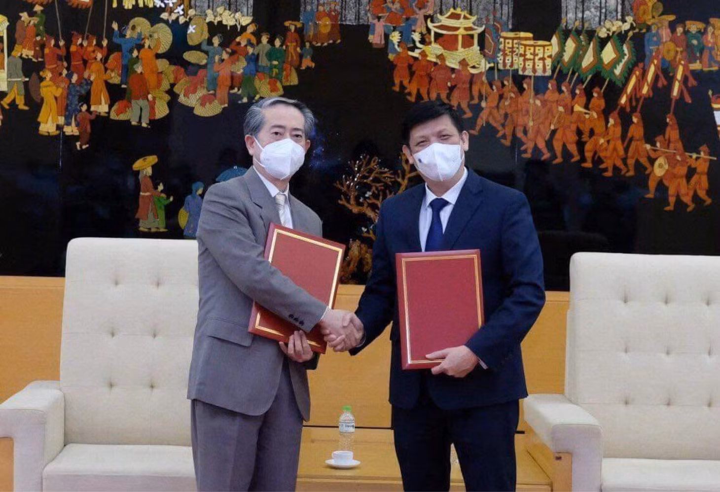 GS.TS Nguyễn Thanh Long - Bộ trưởng Bộ Y tế Việt Nam và ngài Hùng Ba - Đại sứ đặc mệnh toàn quyền nước CHND Trung Hoa - trao biên bản bàn giao lô hàng viện trợ gồm 500.000 liều vaccine và hơn 500.000 bơm kim tiêm. Ảnh: Bộ Y tế cung cấp