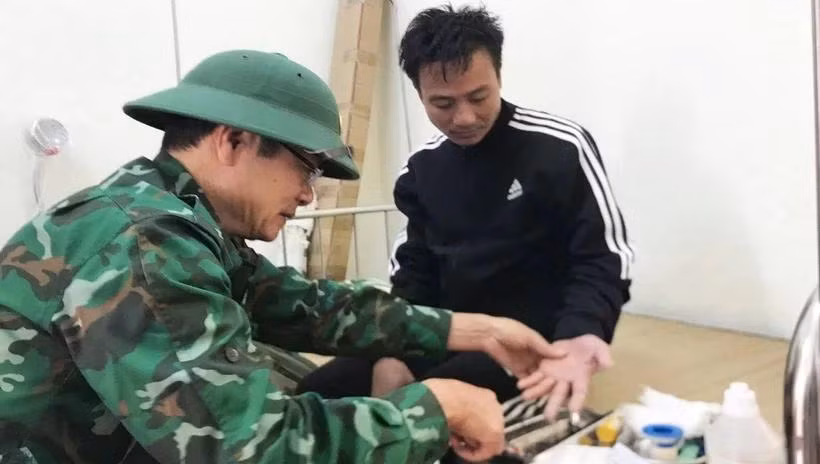 Quân y Hải đội Biên phòng 2 (Bộ đội Biên phòng Quảng Bình) kiểm tra sức khỏe, sơ cứu ngư dân bị nạn. (Ảnh: TTXVN phát)