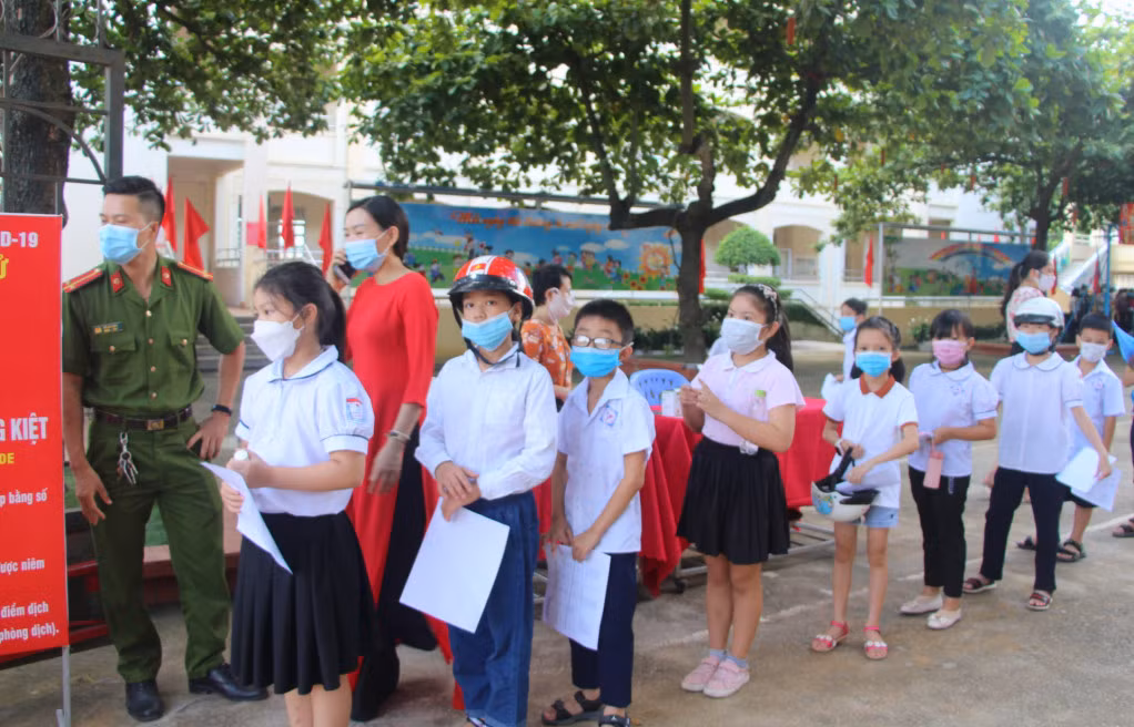Các em học sinh Trường Tiểu học Lý Thường Kiệt (TP Hạ Long) thực hiện các yêu cầu trong công tác phòng, chống dịch ngay từ cổng trường. Ảnh: Thu Chung
