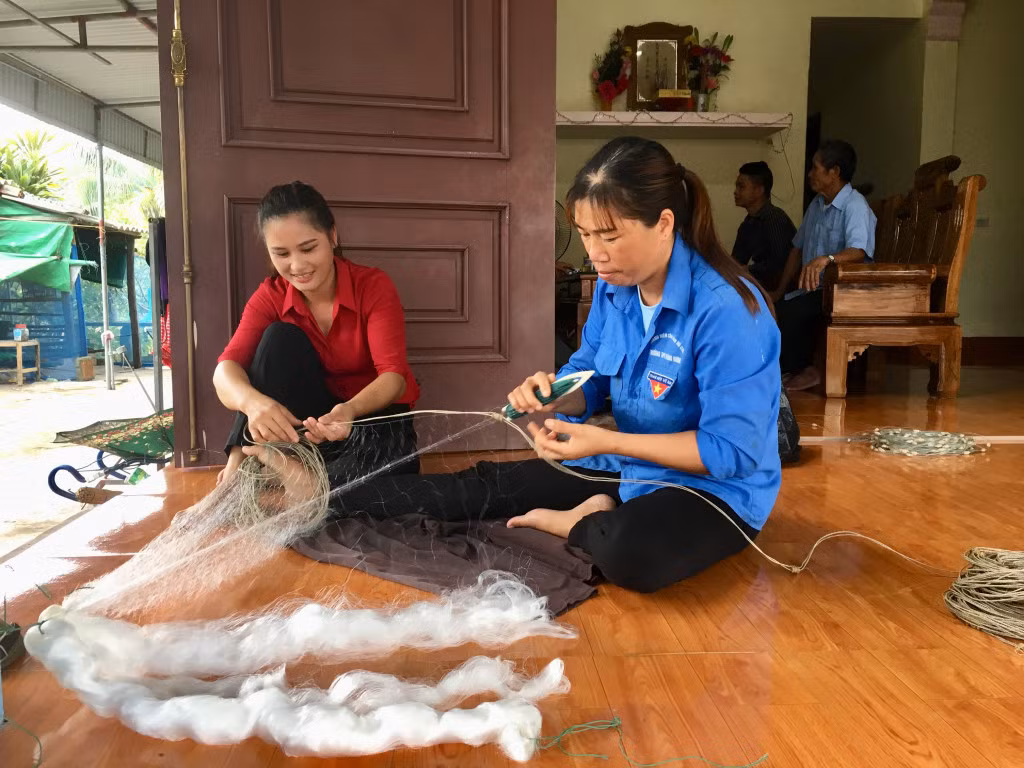 Chị Khổng Thị Ngọ (bên trái) tuyên truyền người dân phát huy nghề truyền thống đánh bắt, nuôi trồng thủy sản.