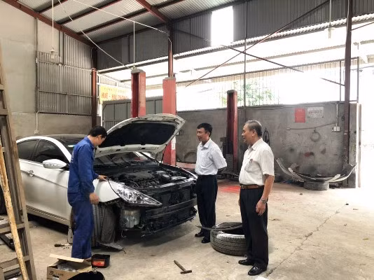 Ông Đinh Văn Thinh (ngoài cùng bên phải) đang trao đổi kỹ thuật với công nhân công ty.