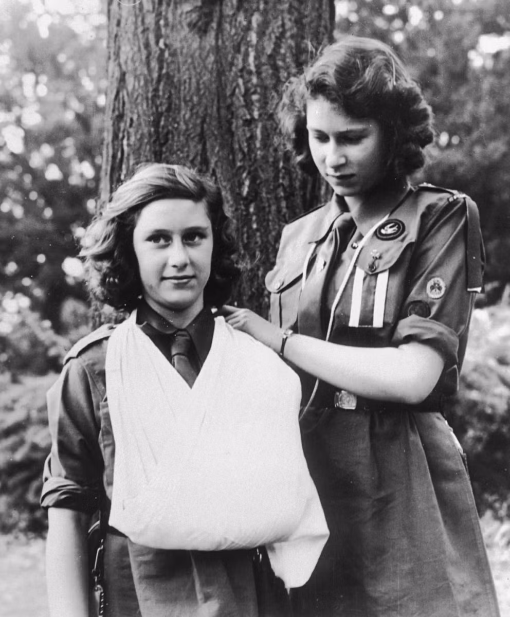 Công chúa Elizabeth (phải) và công chúa Margaret thực tập kỹ năng băng bó vết thương vào năm 1943, khi đang thời kỳ chiến tranh.
