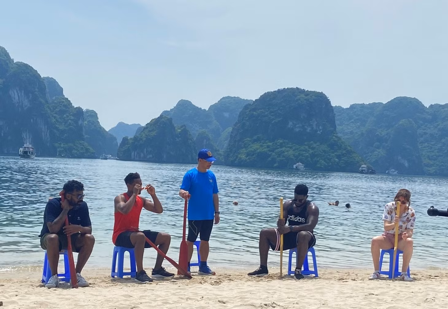 Cựu danh thủ Patrice Evra (áo đỏ) đang học cách dùng mái chèo trên bãi tắm đảo Ti-tốp. Ảnh: CTV