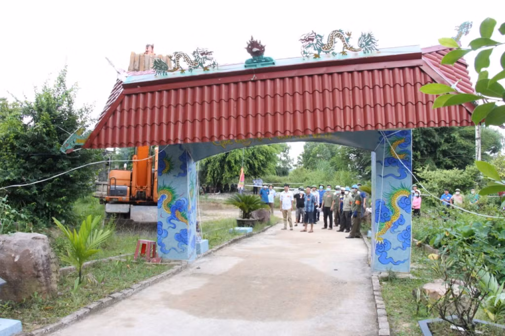 Lực lượng chức năng tổ chức tháo dỡ cổng xây dựng trên đất trồng cây lâu năm.